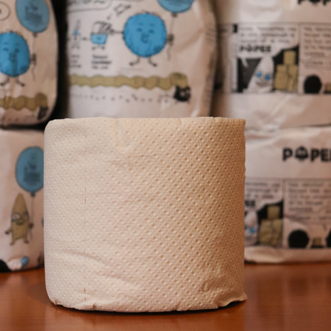 Gros plan sur un rouleau nu Popee sans emballage, texture douce et motif visible sur papier recyclé.