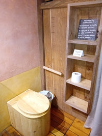 Toilettes sèches en bois avec rouleau Popee sur étagère, écolodge nature.