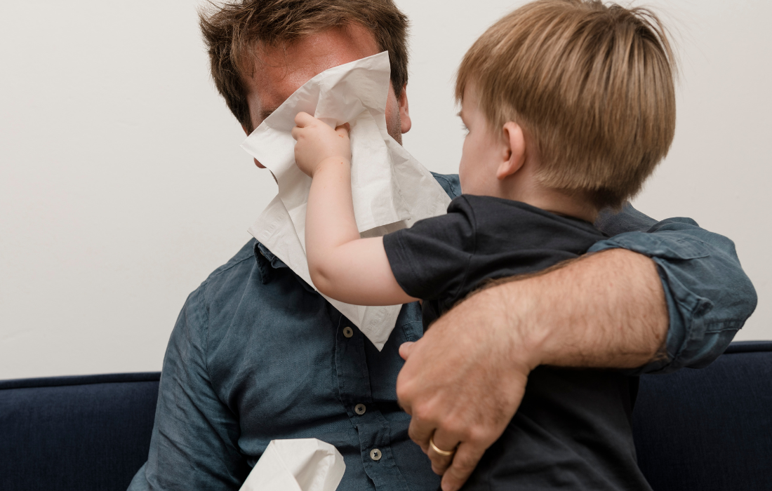 Un enfant essuie tendrement le visage de son père avec un mouchoir Popee, moment complice et doux