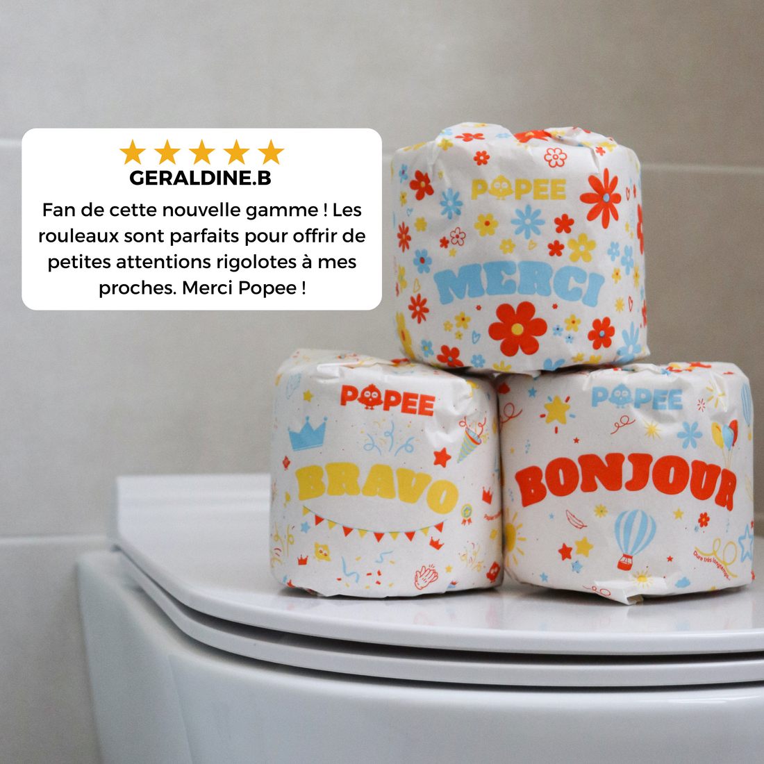 Rouleaux Popee posés sur une cuvette, décorés de messages joyeux avec un avis client enthousiaste en surimpression.