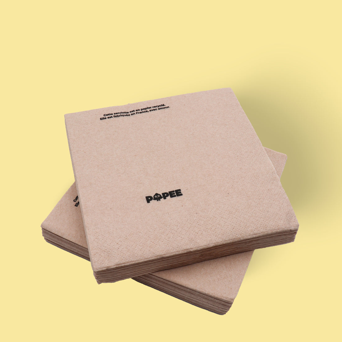 Lot de serviettes de table naturelles en papier recyclé Popee, fond jaune.