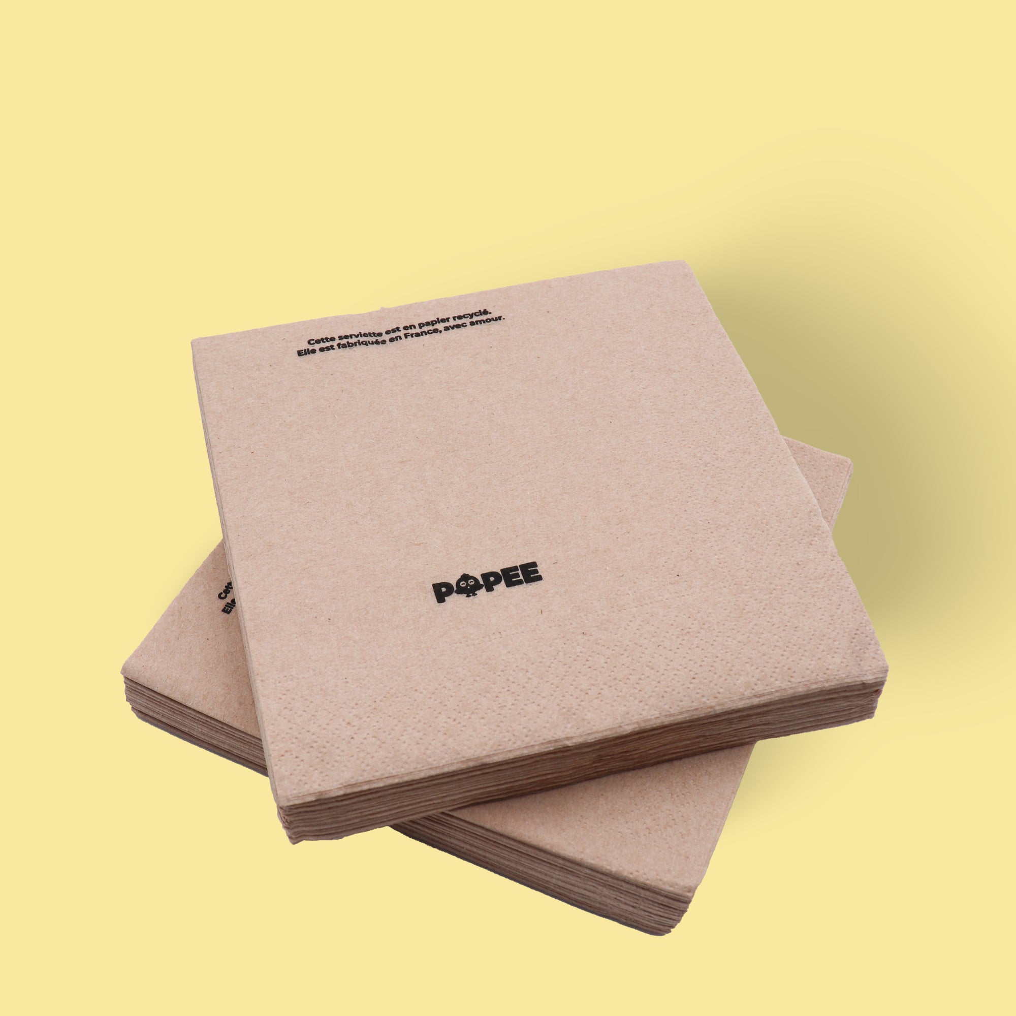 Lot de serviettes de table naturelles en papier recyclé Popee, fond jaune.