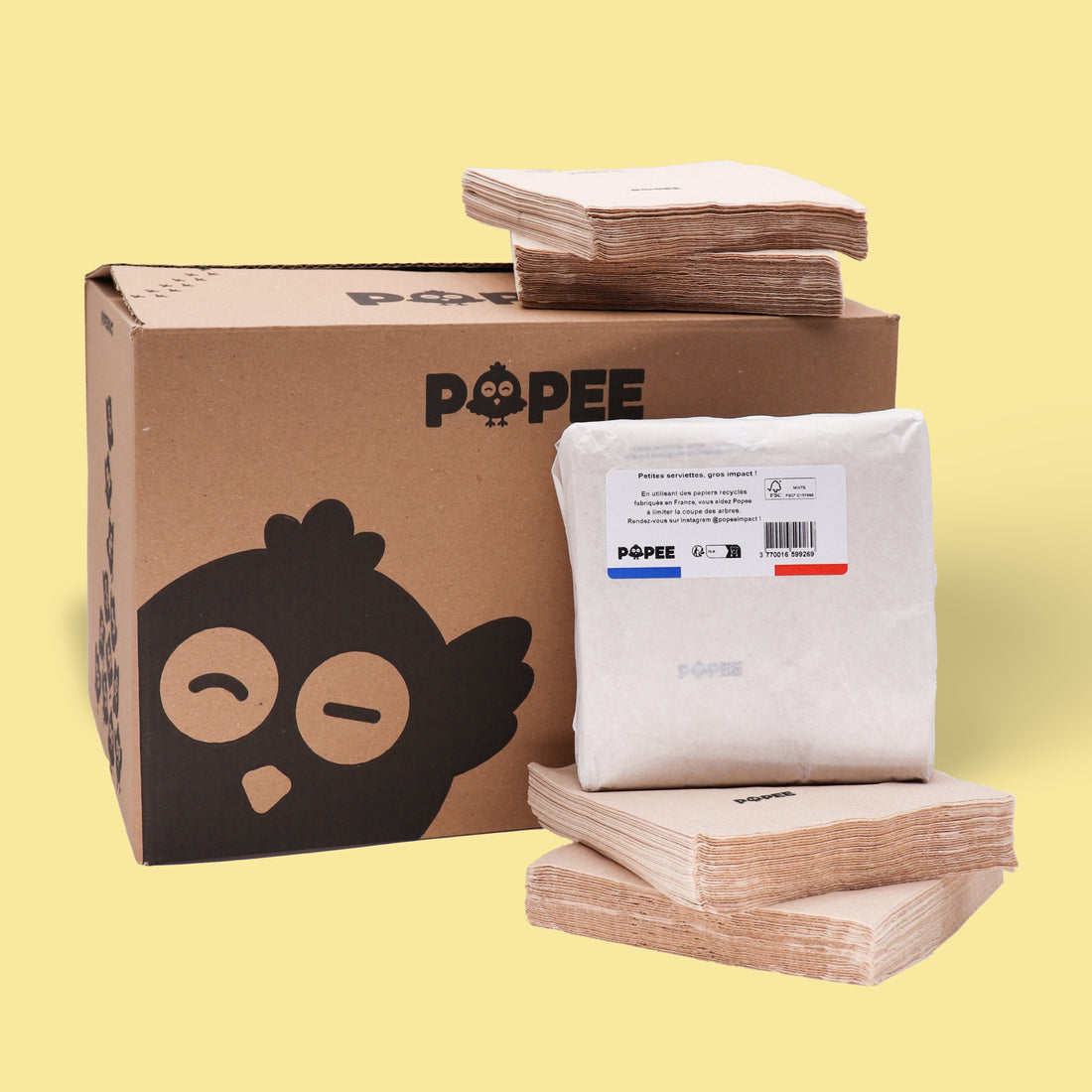 Carton de livraison Popee avec lot de serviettes de table recyclées empilées, fond jaune.
